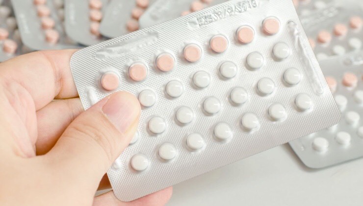 A Woman holding Birth Control Pills