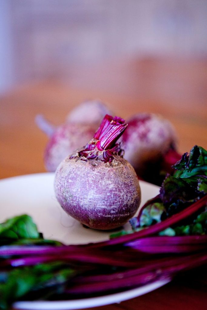an image of beets and beet greens on a white plate