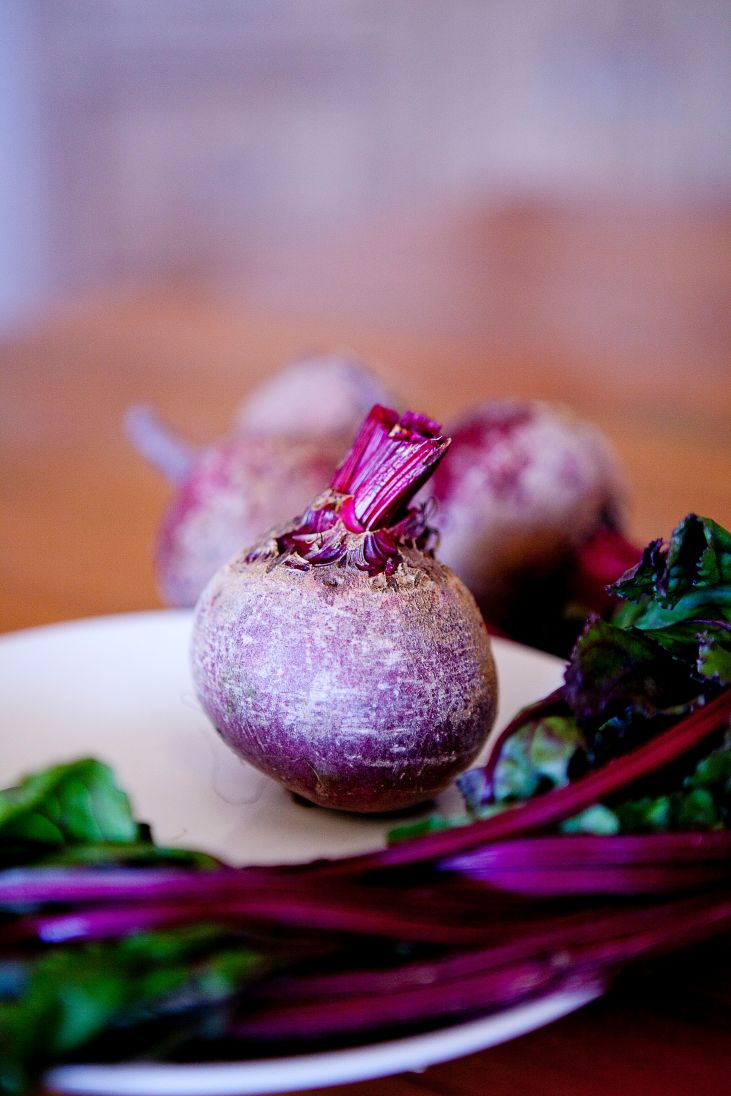 a beet and beet greens on a white plate