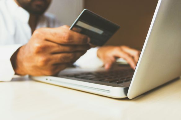 a man holding a credit card next to a computer to cover plantar fasciitis embolization cost 
