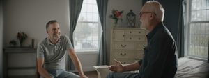 two men sitting on a bed discussing PAE recovery timeline