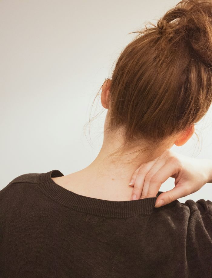 A woman holding her shoulder in discomfort