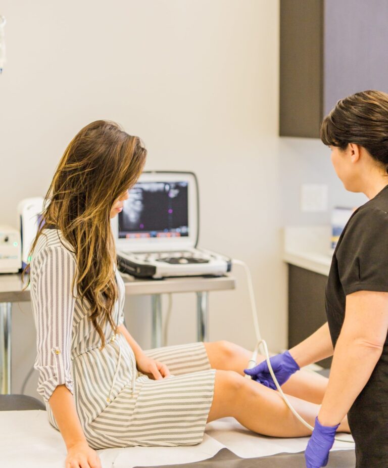 Woman receiving ultrasound vein evaluation
