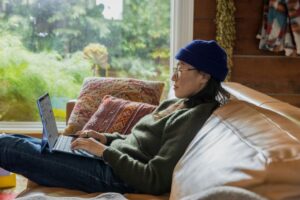 woman on couch holding laptop