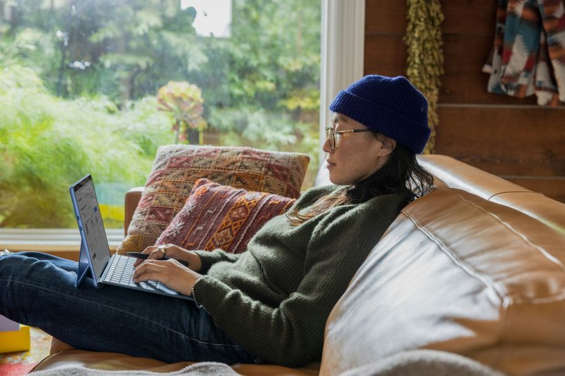 woman sitting on couch with laptop